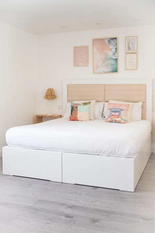 Bright bedroom with a king bed and coastal cushions